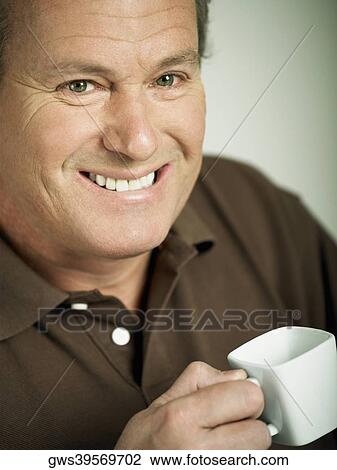 Portrait of a mature man holding a cup of tea and smiling View Large Photo Image Stock Image - Portrait of a mature man holding a cup of tea and smiling. Fotosearch