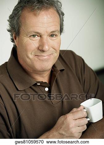 Portrait of a mature man holding a cup of tea View Large Photo Image Stock Image - Portrait of a mature man holding a cup of tea. Fotosearch