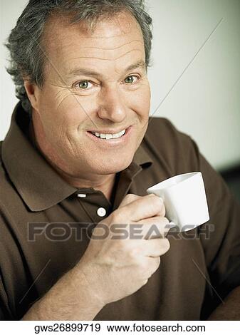 Portrait of a mature man holding a cup of tea and smiling View Large Photo Image Stock Photo - Portrait of a mature man holding a cup of tea and smiling. Fotosearch