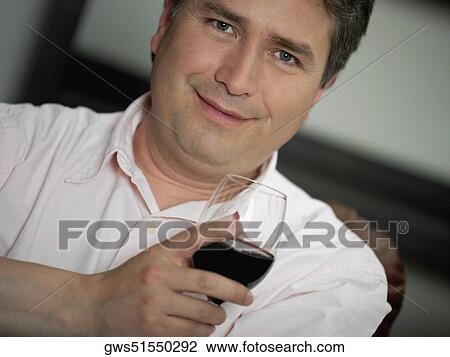 Portrait of a mature man holding a glass of red wine View Large Photo Image Stock Image - Portrait of a mature man holding a glass of red wine. Fotosearch