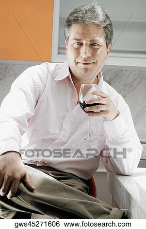 Portrait of a mature man holding a glass of red wine View Large Photo Image Stock Photograph - Portrait of a mature man holding a glass of red wine. Fotosearch