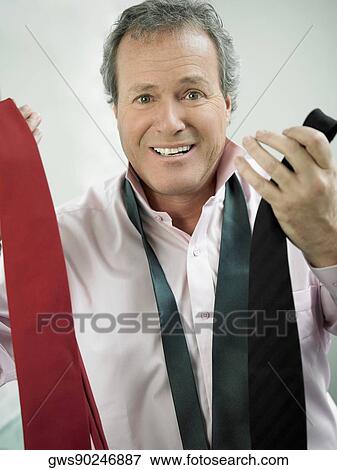 Portrait of a mature man holding ties and looking confused View Large Photo Image Stock Photo - Portrait of a mature man holding ties and looking confused. Fotosearch