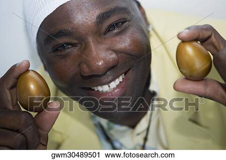 Portrait of a mature man holding two golden eggs View Large Photo Image Stock Image - Portrait of a mature man holding two golden eggs. Fotosearch