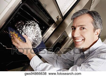 Portrait of a mature man inserting a dish wrapped in foil into a microwave and smiling View Large Photo Image Stock Photo - Portrait of a mature man inserting a dish wrapped in foil into a microwave and smiling. Fotosearch