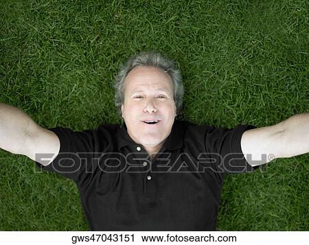 Portrait of a mature man lying on the grass and smiling View Large Photo Image Stock Image - Portrait of a mature man lying on the grass and smiling. Fotosearch