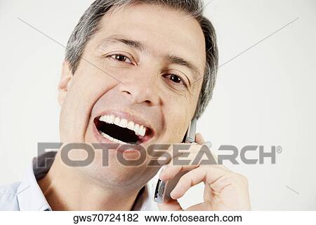 Portrait of a mature man talking on a mobile phone and laughing View Large Photo Image Stock Image - Portrait of a mature man talking on a mobile phone and laughing. Fotosearch