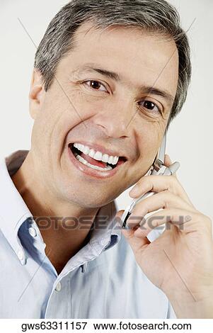 Portrait of a mature man talking on a mobile phone and smiling View Large Photo Image Stock Photo - Portrait of a mature man talking on a mobile phone and smiling. Fotosearch