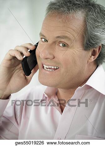 Portrait of a mature man talking on a mobile phone View Large Photo Image Stock Photograph - Portrait of a mature man talking on a mobile phone. Fotosearch