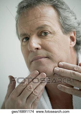 Portrait of a mature man touching his face View Large Photo Image Picture - Portrait of a mature man touching his face. Fotosearch