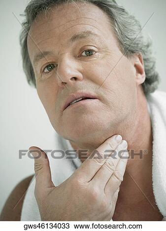 Portrait of a mature man touching his neck View Large Photo Image Stock Image - Portrait of a mature man touching his neck. Fotosearch