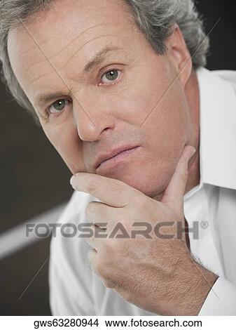 Portrait of a mature man with his hand on his chin View Large Photo Image Picture - Portrait of a mature man with his hand on his chin. Fotosearch