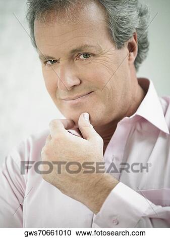 Portrait of a mature man with his hand on his chin View Large Photo Image Stock Image - Portrait of a mature man with his hand on his chin. Fotosearch