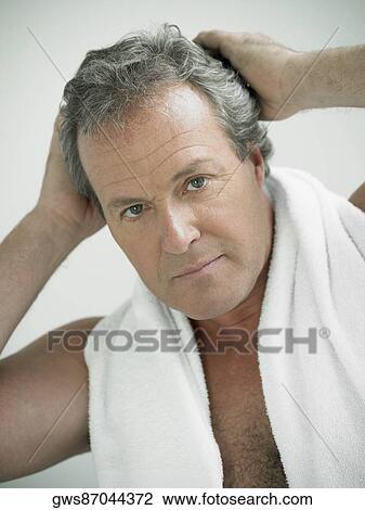 Stock Image - Portrait of a mature man with his hand in his hair. Fotosearch