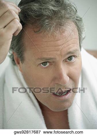 Stock Photo - Portrait of a mature man with his hand in his hair. Fotosearch