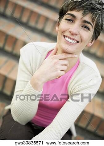 Portrait of a mature woman sitting on steps and smiling View Large Photo Image Stock Image - Portrait of a mature woman sitting on steps and smiling. Fotosearch