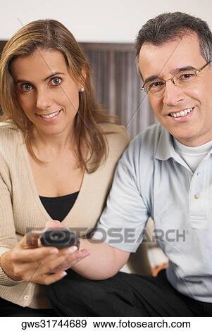 Portrait of a mid adult couple using a remote control View Large Photo Image Stock Photo - Portrait of a mid adult couple using a remote control. Fotosearch