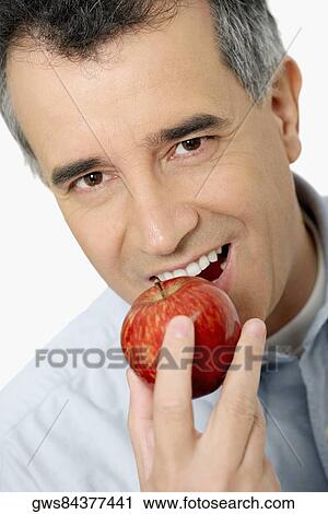 Portrait of a mid adult man eating an apple View Large Photo Image Stock Image - Portrait of a mid adult man eating an apple. Fotosearch
