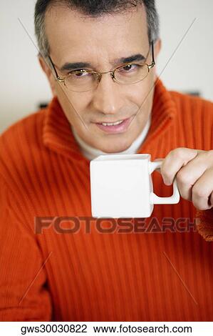 Portrait of a mid adult man holding a cup of coffee View Large Photo Image Stock Image - Portrait of a mid adult man holding a cup of coffee. Fotosearch