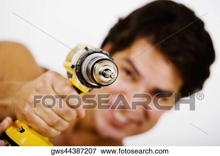 Portrait of a mid adult man holding a drill machine View Large Photo Image Stock Photo - Portrait of a mid adult man holding a drill machine. Fotosearch