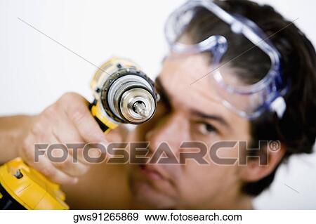 Portrait of a mid adult man holding a drill machine View Large Photo Image Stock Photo - Portrait of a mid adult man holding a drill machine. Fotosearch