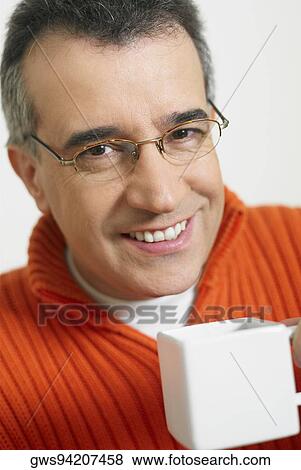 Portrait of a mid adult man holding a cup of coffee View Large Photo Image Stock Photo - Portrait of a mid adult man holding a cup of coffee. Fotosearch