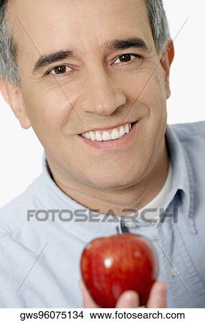 Portrait of a mid adult man holding an apple View Large Photo Image Picture - Portrait of a mid adult man holding an apple. Fotosearch