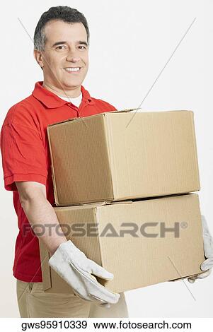 Portrait of a mid adult man holding cardboard boxes View Large Photo Image Stock Photo - Portrait of a mid adult man holding cardboard boxes. Fotosearch