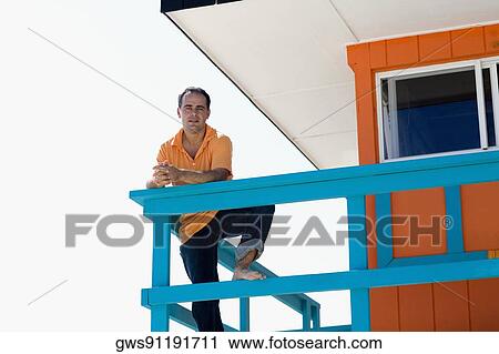 Portrait of a mid adult man leaning against the railing of a lifeguard hut View Large Photo Image Stock Image - Portrait of a mid adult man leaning against the railing of a lifeguard hut. Fotosearch