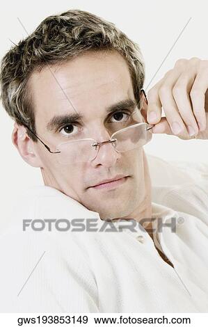 Portrait of a mid adult man peeking over his eyeglasses View Large Photo Image Stock Photo - Portrait of a mid adult man peeking over his eyeglasses. Fotosearch