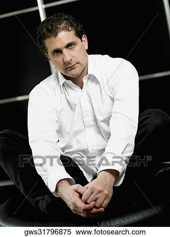 Portrait of a mid adult man sitting and holding his feet View Large Photo Image Stock Photography - Portrait of a mid adult man sitting and holding his feet. Fotosearch