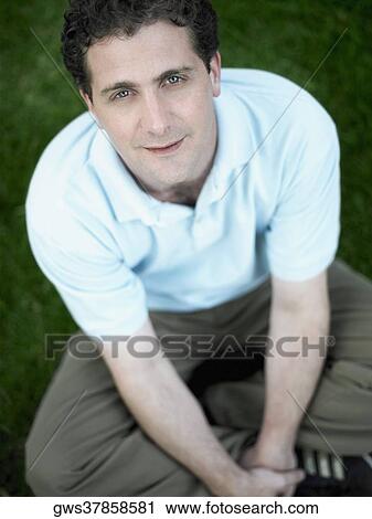 Portrait of a mid adult man sitting in a park and smiling View Large Photo Image Stock Image - Portrait of a mid adult man sitting in a park and smiling. Fotosearch