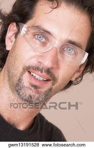 Stock Photo - Portrait of a mid adult man wearing protective eyewear. Fotosearch