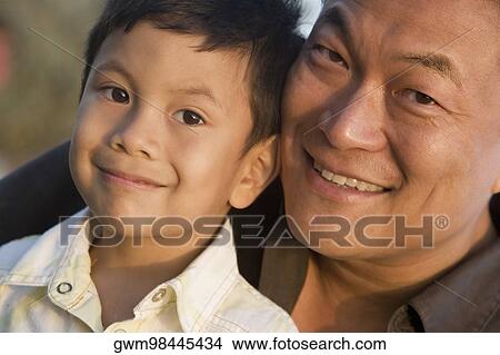Picture - Portrait of a mid adult man with his son smiling. Fotosearch