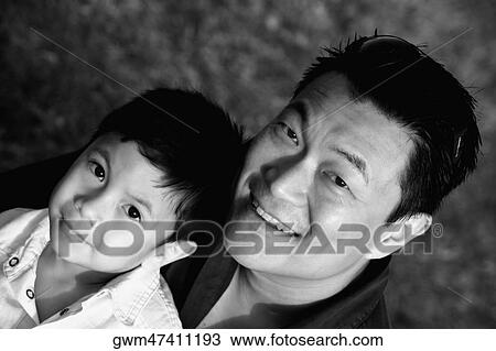 Portrait of a mid adult man with his son smiling View Large Photo Image Stock Image - Portrait of a mid adult man with his son smiling. Fotosearch