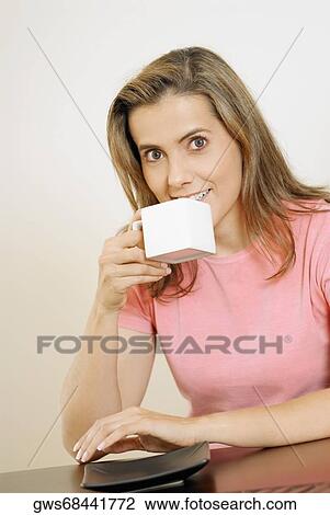 Portrait of a mid adult woman drinking a cup of coffee View Large Photo Image Stock Image - Portrait of a mid adult woman drinking a cup of coffee. Fotosearch