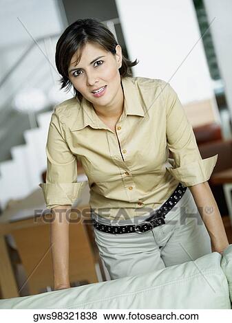 Portrait of a mid adult woman leaning over a couch and smiling View Large Photo Image Stock Photo - Portrait of a mid adult woman leaning over a couch and smiling. Fotosearch