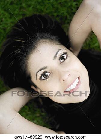 Portrait of a mid adult woman lying on a lawn and smiling View Large Photo Image Stock Photo - Portrait of a mid adult woman lying on a lawn and smiling. Fotosearch