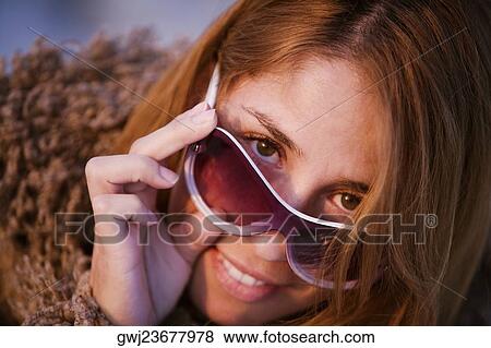 Portrait of a mid adult woman peeking over her sunglasses View Large Photo Image Stock Photo - Portrait of a mid adult woman peeking over her sunglasses. Fotosearch