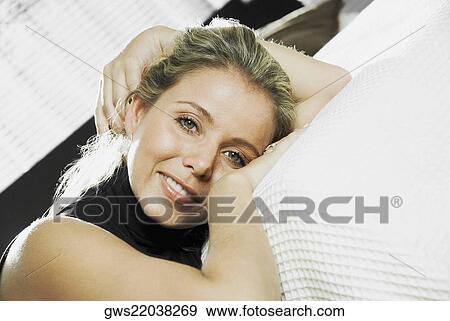Portrait of a mid adult woman reclining on the bed View Large Photo Image Stock Photo - Portrait of a mid adult woman reclining on the bed. Fotosearch