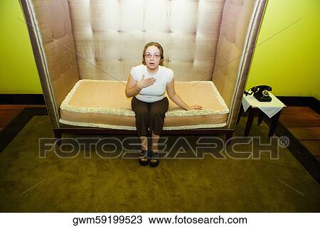 Portrait of a mid adult woman sitting in an armchair and looking surprised View Large Photo Image Stock Image - Portrait of a mid adult woman sitting in an armchair and looking surprised. Fotosearch