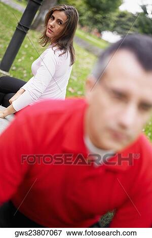 Portrait of a mid adult woman sitting behind a mid adult man View Large Photo Image Stock Photo - Portrait of a mid adult woman sitting behind a mid adult man. Fotosearch