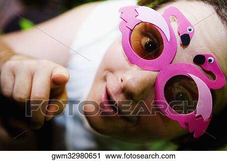 Stock Image - Portrait of a mid adult woman wearing sunglasses. Fotosearch