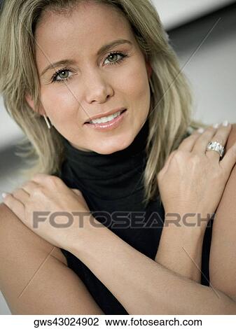 Stock Image - Portrait of a mid adult woman with her arms crossed. Fotosearch