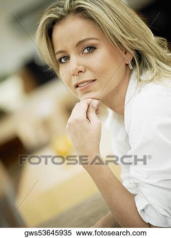 Stock Photography - Portrait of a mid adult woman with her hand on her chin. Fotosearch
