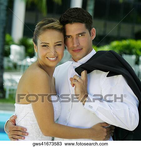 Stock Image - Portrait of a newlywed couple embracing each other. Fotosearch