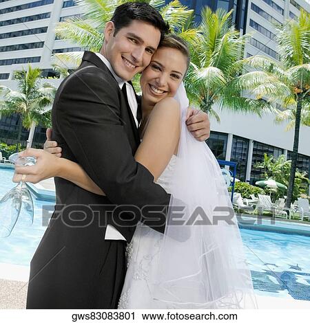 Portrait of a newlywed couple embracing each other View Large Photo Image Stock Image - Portrait of a newlywed couple embracing each other. Fotosearch