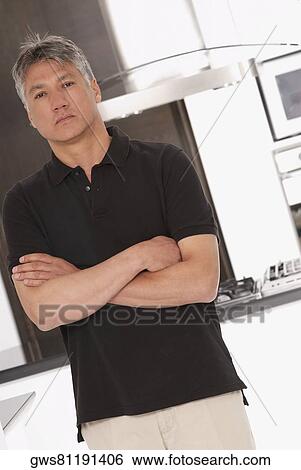 Portrait of a senior man standing with his arms folded View Large Photo Image Stock Photograph - Portrait of a senior man standing with his arms folded. Fotosearch