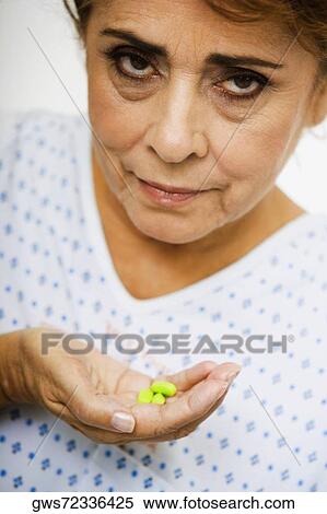Portrait of a senior woman holding pills View Large Photo Image Stock Photography - Portrait of a senior woman holding pills. Fotosearch