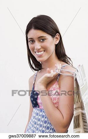 Portrait of a teenage girl carrying a shopping bag and smiling View Large Photo Image Stock Photo - Portrait of a teenage girl carrying a shopping bag and smiling. Fotosearch