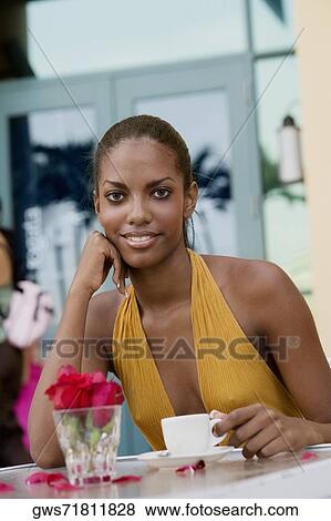 Stock Photo - Portrait of a teenage girl sitting at a restaurant with a cup of coffee . Fotosearch